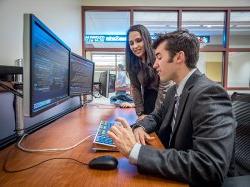 费利西亚诺商学院(费利西亚诺商学院)的学生正在用双显示器分析股票.